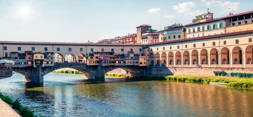 Beautiful medieval arched river bridge with Roman origins - Ponte Vecchio over Arno river. Bright spring morning panorama of Florence, Italy, Europe. Traveling concept background.