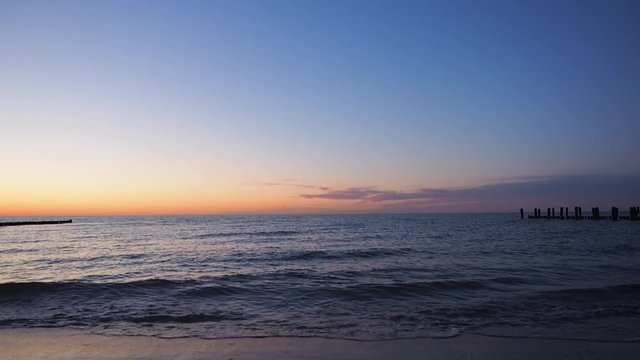 Wellen bei Sonnenuntergang mit Buhnen