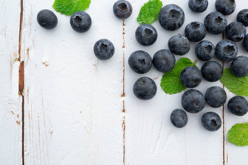 organic blueberries and leaves in wooden background, flavor concept 