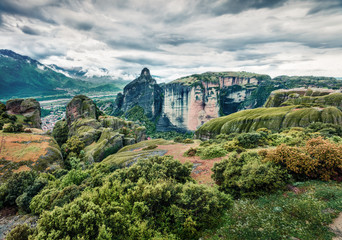 Obraz premium Clody spring scene of Meteora, UNESCO World Heritage site. Beautiful morning view of Eastern Orthodox monasteries, built on top of rock pillars. Kalambaka village location, Greece, Europe.