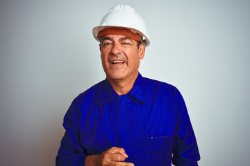 Handsome middle age worker man wearing uniform and helmet over isolated white background winking...