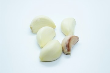 Garlic cloves are located on a white background.