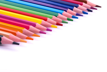 Colored sharpened wooden pencils lie on a white sheet of paper for creativity, drawing, notes, texts and letters