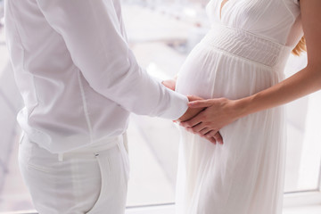 Happy parents pregnant woman heart symbol love husband touching tummy