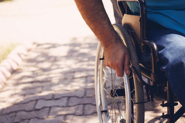 Disabled man on wheelchair in the outdoor park like other people, Close-Up his wheel, Life in the...