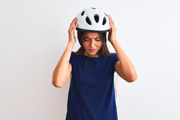 Young beautiful cyclist woman wearing security bike helmet over isolated white background suffering from headache desperate and stressed because pain and migraine. Hands on head.