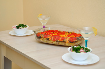 Meat dish with mushrooms, tomatoes and melted cheese