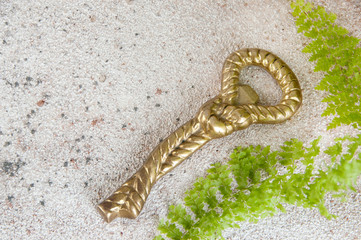 Antique brass bottle-opener on concrete background