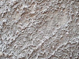 background is very old textured concrete with many protrusions and depressions