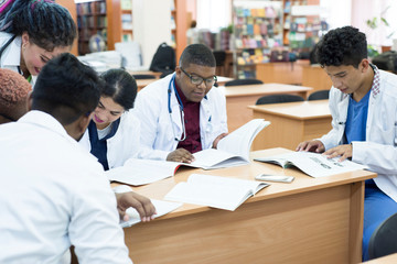 a group of young doctors, mixed race. Sitting at the table, colleagues discuss medical topics