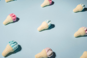 Trendy sunlight Summer pattern made with pink strawberry ice cream on bright light blue background. Minimal summer concept.