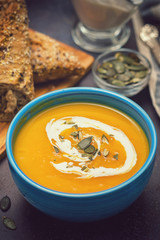 Homemade pumpkin soup served with cream and pumpkin seeds