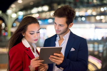 People using tablet at night in a city