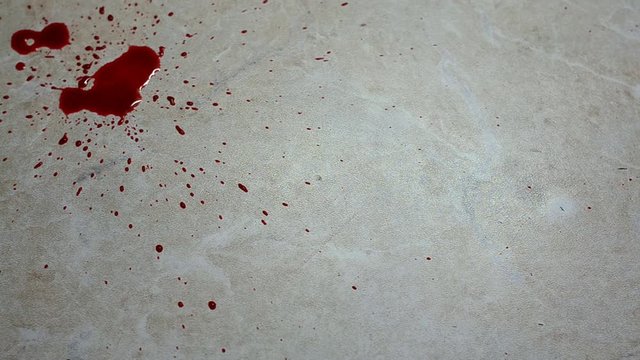 Close-up top view falling drops of red blood on light neutral background and copy space