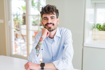 Handsome young man smiling cheerful at the camera with a big smile on face showing teeth