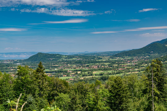  City landscape in the mountains, hills, fields, forests, green meadows, lakes in the distance and blue sky with clouds,focus area in the city.Haute-Savoie in France.