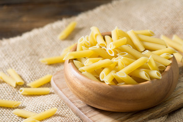 Pasta in a wooden bowl on a wooden table. Rustic style