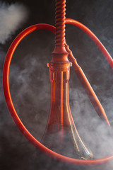  smoky red hookah on a black background, and around a cloud of tobacco smoke