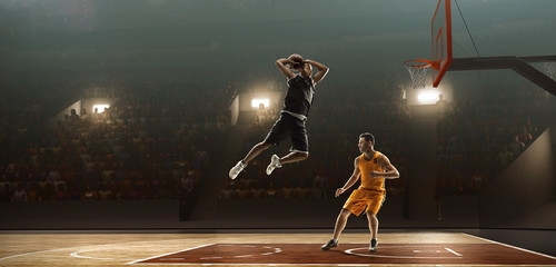 Basketball players in action with the ball. Basketball court with spectators. Dunking