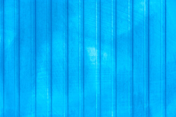 Blue background. Weathered profiled steel sheets on an industrial building. Vertical blue metal profiles with copy space.
