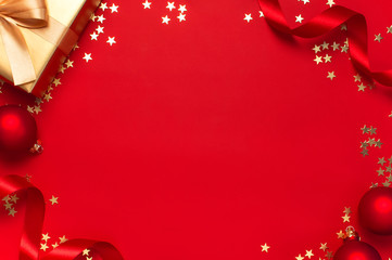 New Year Christmas golden presents with ribbon, Christmas balls, gold confetti stars on red...