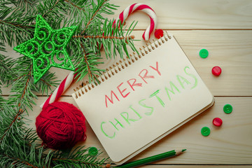 Composition with Christmas tree, notebook, yarn balls  and buttons as decorations on wooden...