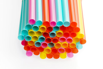 A pile of colourful plastic straws on white background.
