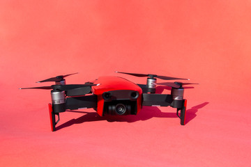 Drone quadcopter with camcorder on red background