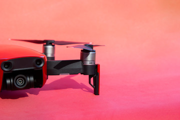 Drone quadcopter with camcorder on red background