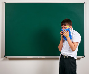 Portrait of funny pupil. School boy very emotional, having fun and very happy, blackboard...