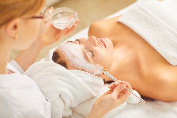 Obraz na płótnie Canvas Woman having a facial cosmetic mask in spa salon.