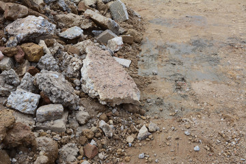 Broken pieces of concrete and bricks next to excavated ground
