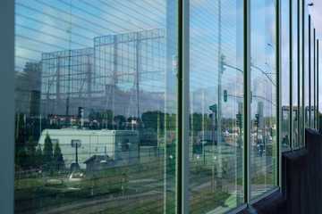 Obraz premium Acoustic road screen (sound absorbing panel) next to the expressway. Moving cars visible through the glass.