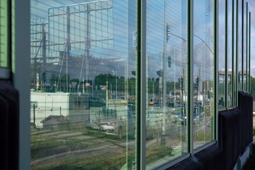 Fototapeta na wymiar Acoustic road screen (sound absorbing panel) next to the expressway. Moving cars visible through the glass.