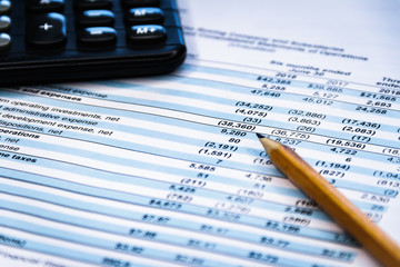 Financial income statement with calculator and pencil