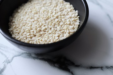 white lentil urad dal in black bowl on gray marble background
