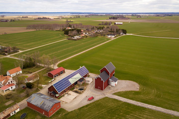 Top view of rural landscape on sunny spring day. Farm with solar photo voltaic panels system on...
