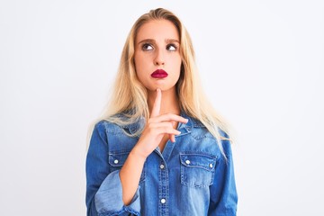 Young beautiful woman wearing casual denim shirt standing over isolated white background Thinking concentrated about doubt with finger on chin and looking up wondering