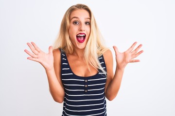 Young beautiful woman wearing casual striped t-shirt standing over isolated white background celebrating crazy and amazed for success with arms raised and open eyes screaming excited. Winner concept