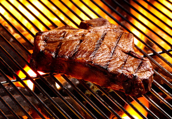 BBQ Juicy T-Bone Steak on Grill with coal and flames