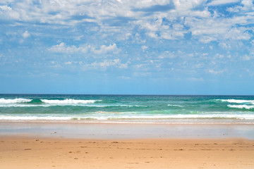 Fototapeta premium Stunning panoramic view of the ocean and beautiful waves rolling in on a sandy beach.