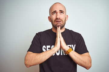 Young safeguard man wearing security uniform over isolated background begging and praying with...