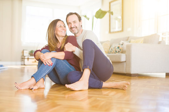 Beautiful romantic couple sitting together on the floor at home