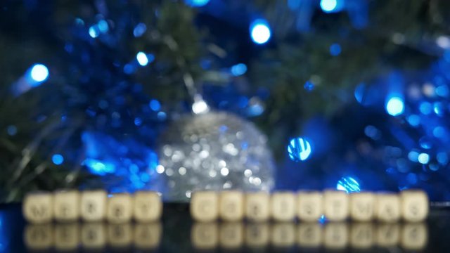Cristmas in letters. The inscription merry christmas on the background of the decorated fir tree.