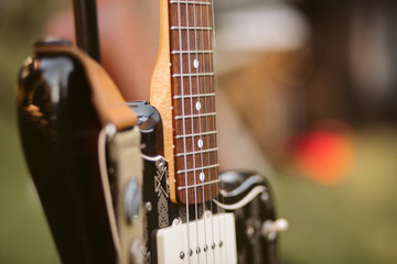 Fototapeta premium Close up of electric guitar. Detail of the strings. Electric guitar on a stand before a concert. Guitar ready to be played. Music concept.