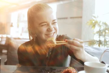  meisje eet sushi en rolt in een restaurant / oosterse keuken, Japans eten, jong model in een restaurant © kichigin19