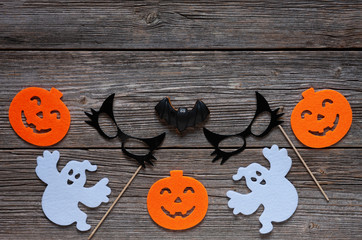 Silhouette of scary pumpkin, ghosts, black cat mask and bat - concept for Halloween on a vintage wooden background