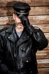 handsome sexy bearded man dressed in black leather
