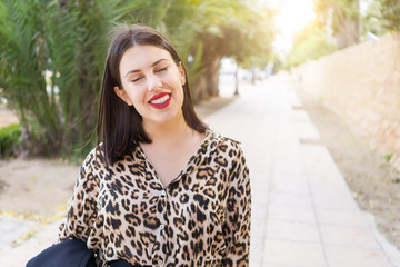 Young beautiful woman with red lips smiling happy at garden