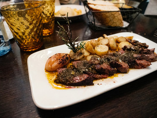 Delicious duck meat on white plate served with new potatoes and oregano